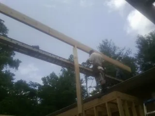 Carpenter setting a ridge beam over a new addition frame — Ice Dam Removal by Roofing Brothers in Lynden