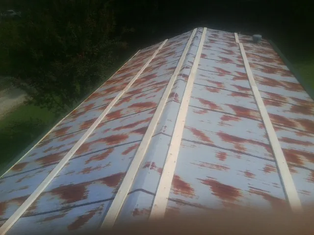Rusted metal roof panels with new wood purlins before replacement — Storm Damage Roof Repair in Lynden by Roofing Brothers